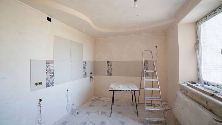 Cocina en obra vacía, con tomas de agua y luz preparadas y una ventana amplia por donde entrarán los muebles